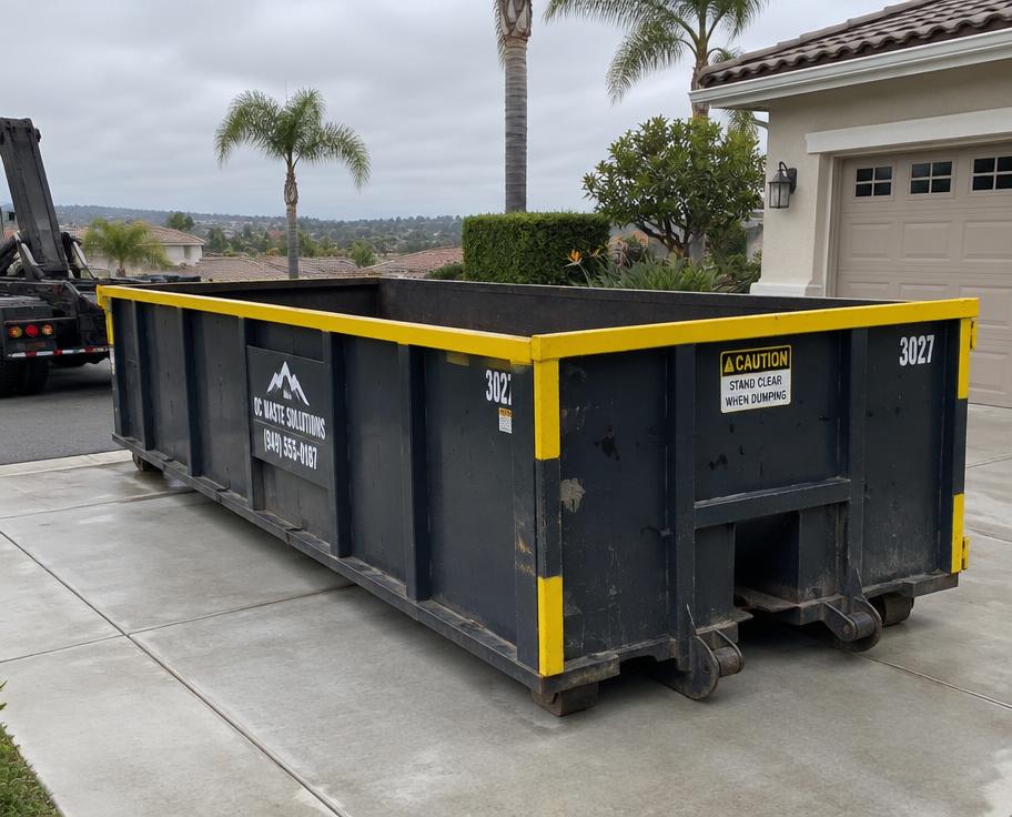 Steel roll-off dumpster placed on a residential driveway in Orange County